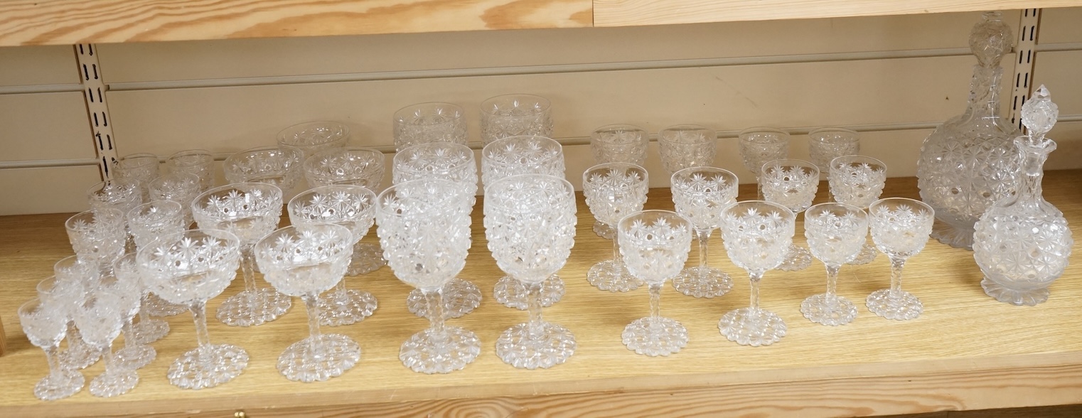 A Victorian heavy hobnail and star cut suite of table glass to include champagnes glasses and two decanters, largest 29cm high